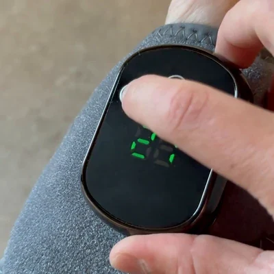 Close-up of an index finger pressing the center of the black Stepeva control module screen